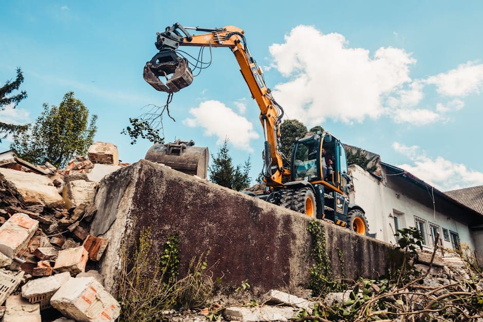 Derribo de edificio con excavadora y contenedor de escombros