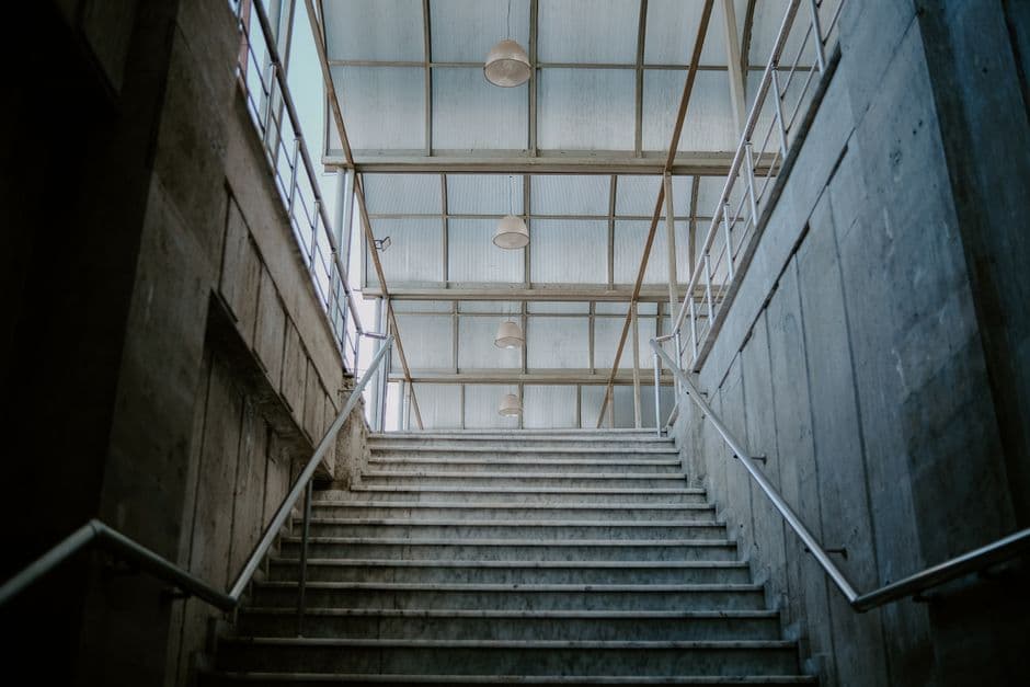 Escalera de hormigón visto con acabado liso en un interior contemporáneo con iluminación lateral