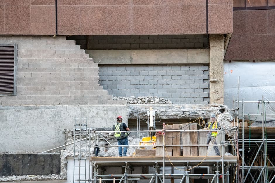 Operarios colocando paneles de encofrado metálico en un muro de hormigón en obra