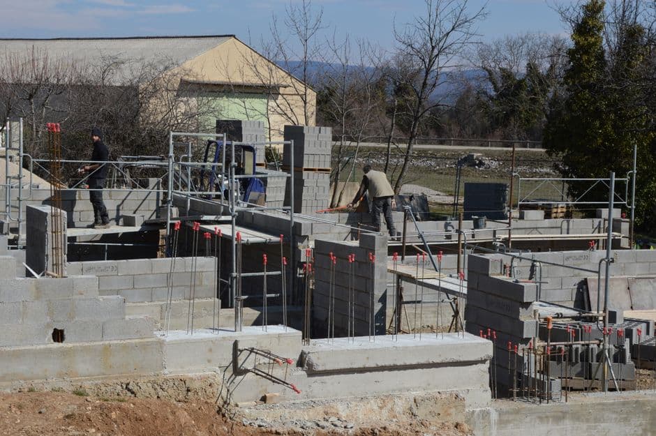 Operarios instalando módulos de encofrado perdido para forjado sanitario ventilado en obra de nueva construcción