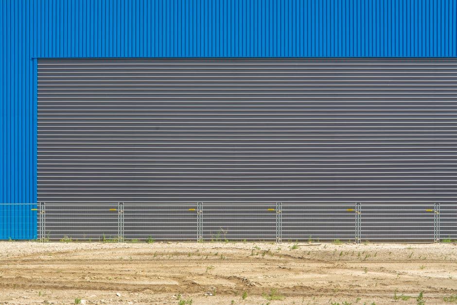 Construcción de un almacén industrial con estructura metálica vista desde el exterior durante la fase de obra
