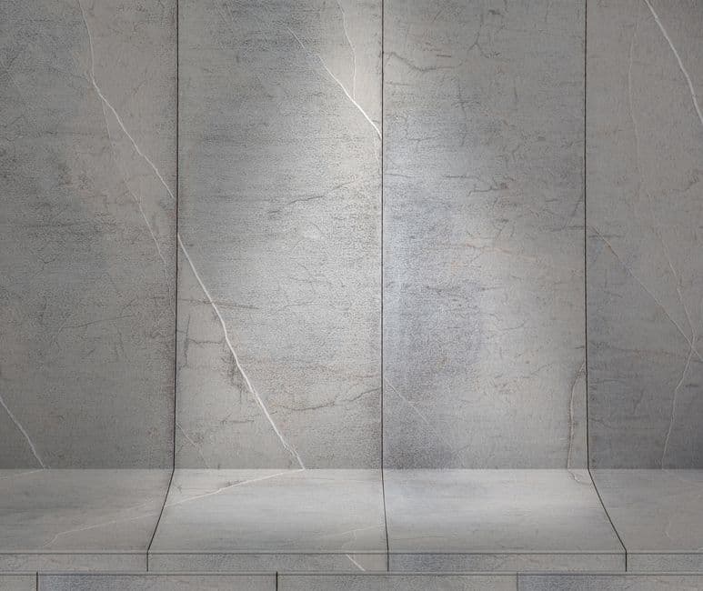 Operario colocando paneles de piedra natural Stonepanel en una pared interior de salón