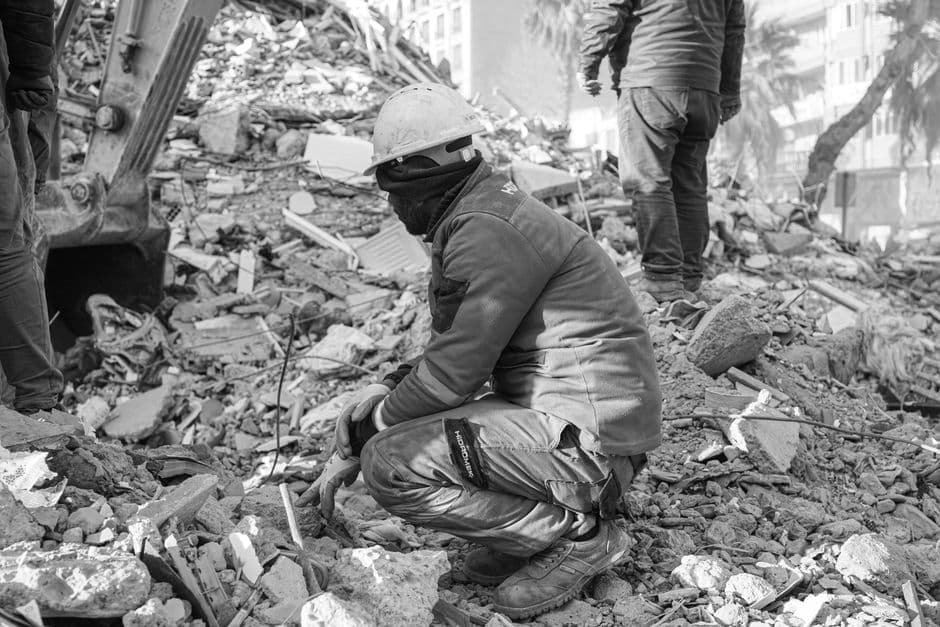 Operario aplicando gunita con manguera sobre talud de tierra en obra de infraestructura