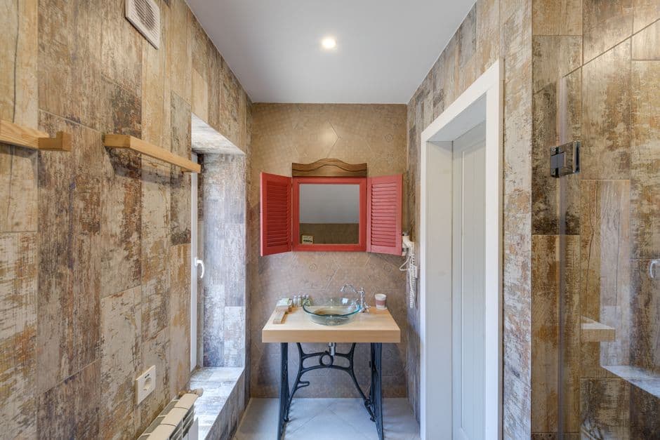 Baño revestido con tadelakt de cal pulida en tono gris verdoso, con textura artesanal y acabado impermeabilizado