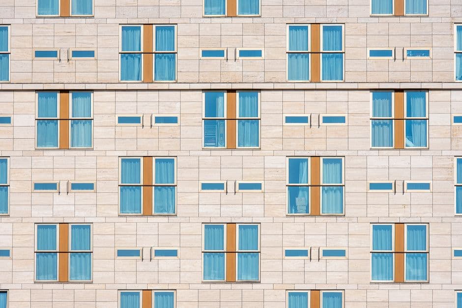 Fachada de edificio revestida con placas de travertino natural en tono beige cálido